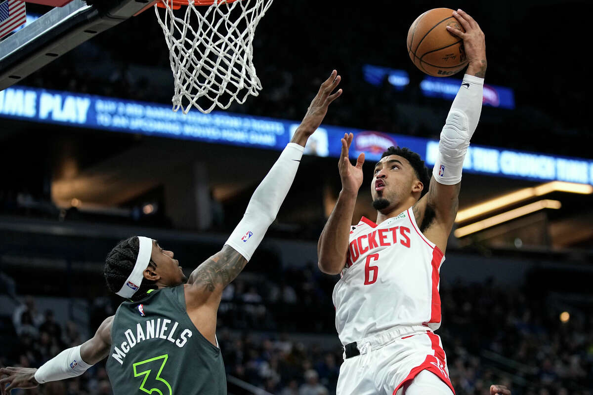 Houston Rockets forward Kenyon Martin Jr. (6) shoots while defended by Minnesota Timberwolves forward Jaden McDaniels (3) during the second half of an NBA basketball game, Saturday, Jan. 21, 2023, in Minneapolis. (AP Photo/Abbie Parr)