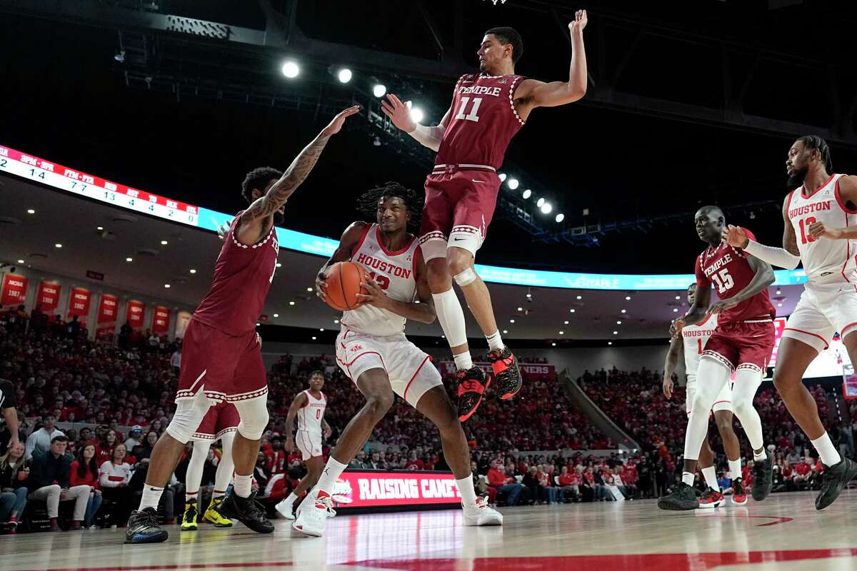 Houston's Tramon Mark (12) is fouled by Temple's Nick Jourdain (11) as Damian Dunn (1) helps defend during the first half of an NCAA college basketball game Sunday, Jan. 22, 2023, in Houston.