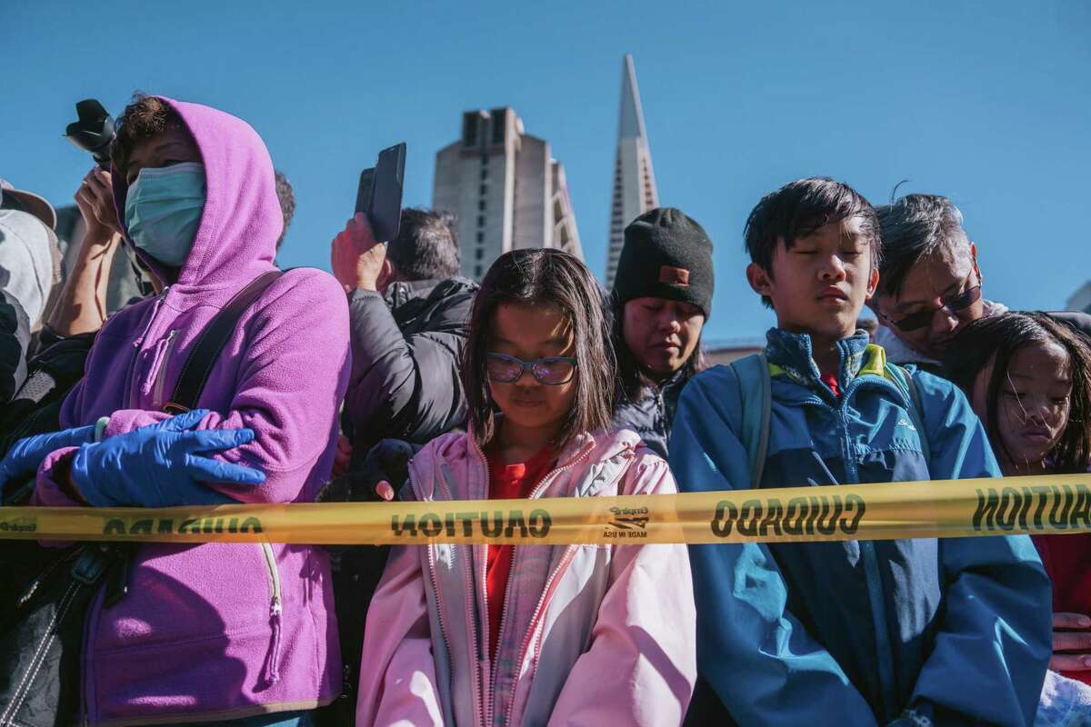 A crowd in S.F. gathered to celebrate the Lunar New Year on Jan. 22 observes a moment of silence for the Monterey Park (Los Angeles County) shooting victims, who were predominantly Asian American. 