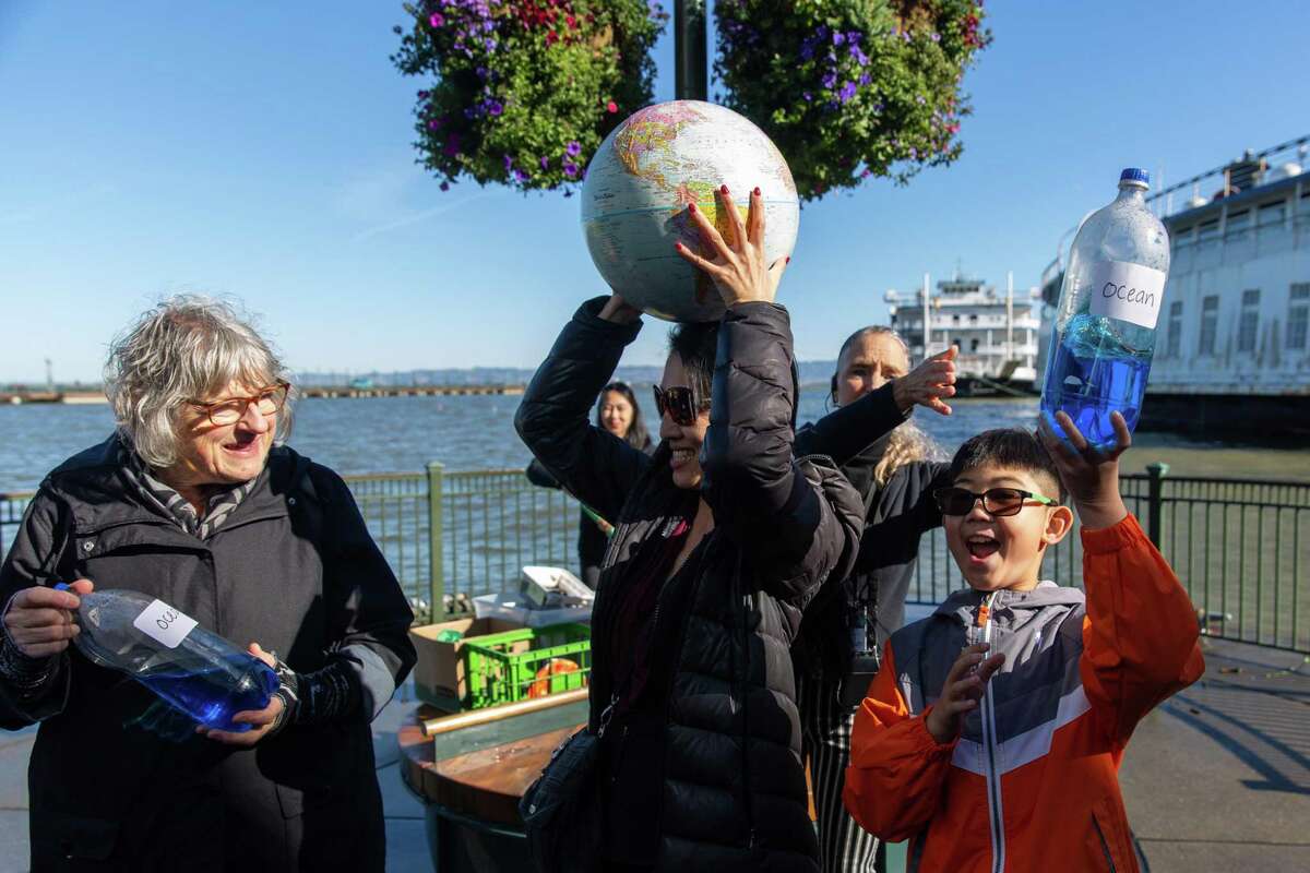 Guests participate in an Exploratorium-sponsored presentation explaining how the Earth, oceans, moon and sun are involved in tides during a high tide day in San Francisco.