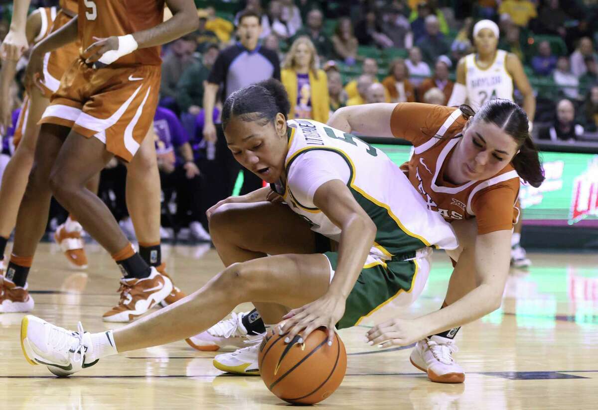 Baylor guard Darianna Littlepage-Buggs (5) reaches back while grabbing the ball over Texas guard Shaylee Gonzales in the second half of an NCAA college basketball game, Sunday, Jan. 22, 2023, in Waco, Texas. (Rod Aydelotte/Waco Tribune-Herald via AP)