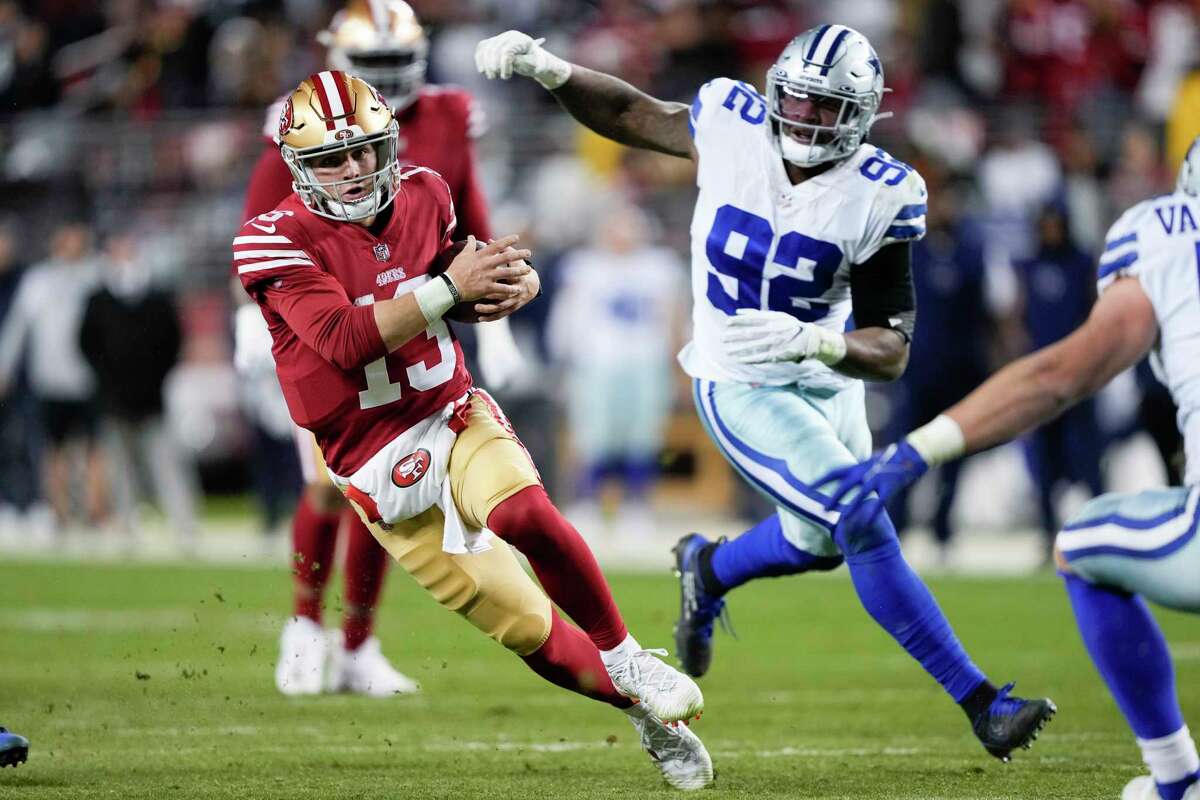 San Francisco 49ers quarterback Brock Purdy (13) runs against Dallas Cowboys defensive end Dorance Armstrong (92) during the second half of an NFL divisional round playoff football game in Santa Clara, Calif., Sunday, Jan. 22, 2023.