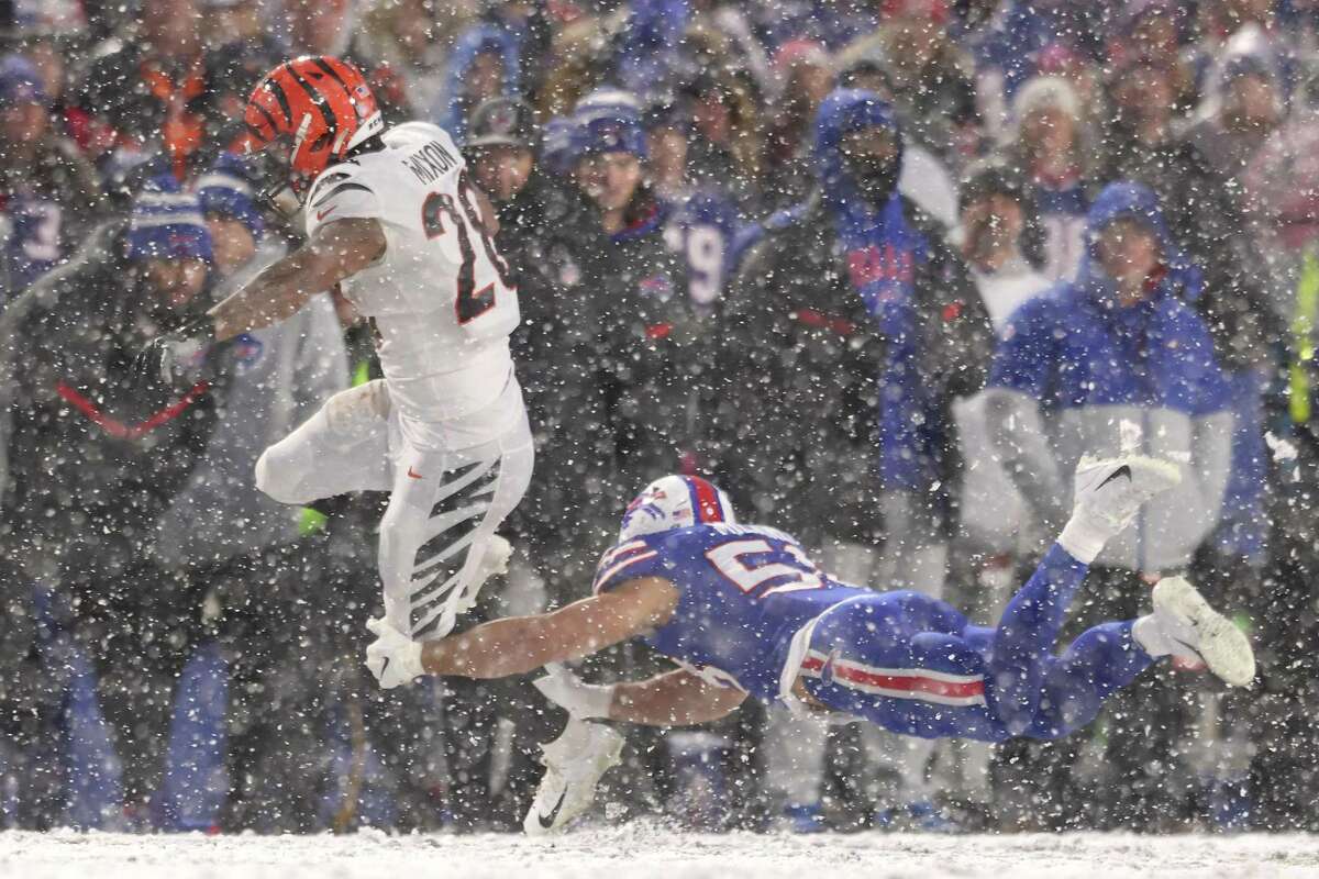 Cincinnati’s Joe Mixon tries to elude a diving tackle attempt by Buffalo’s Matt Milano in the fourth quarter.