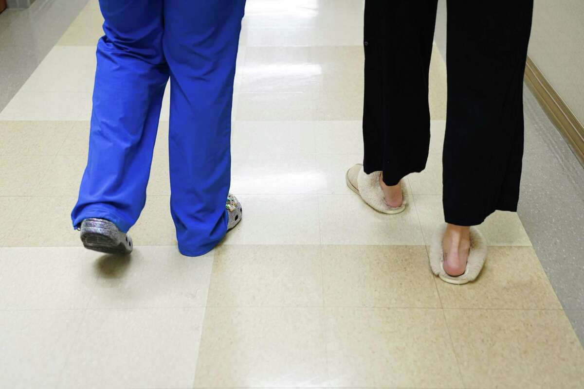 A nurse walks with a patient in the Mother Baby Unit of The Woman’s Hospital of Texas in Houston on January 20, 2023.