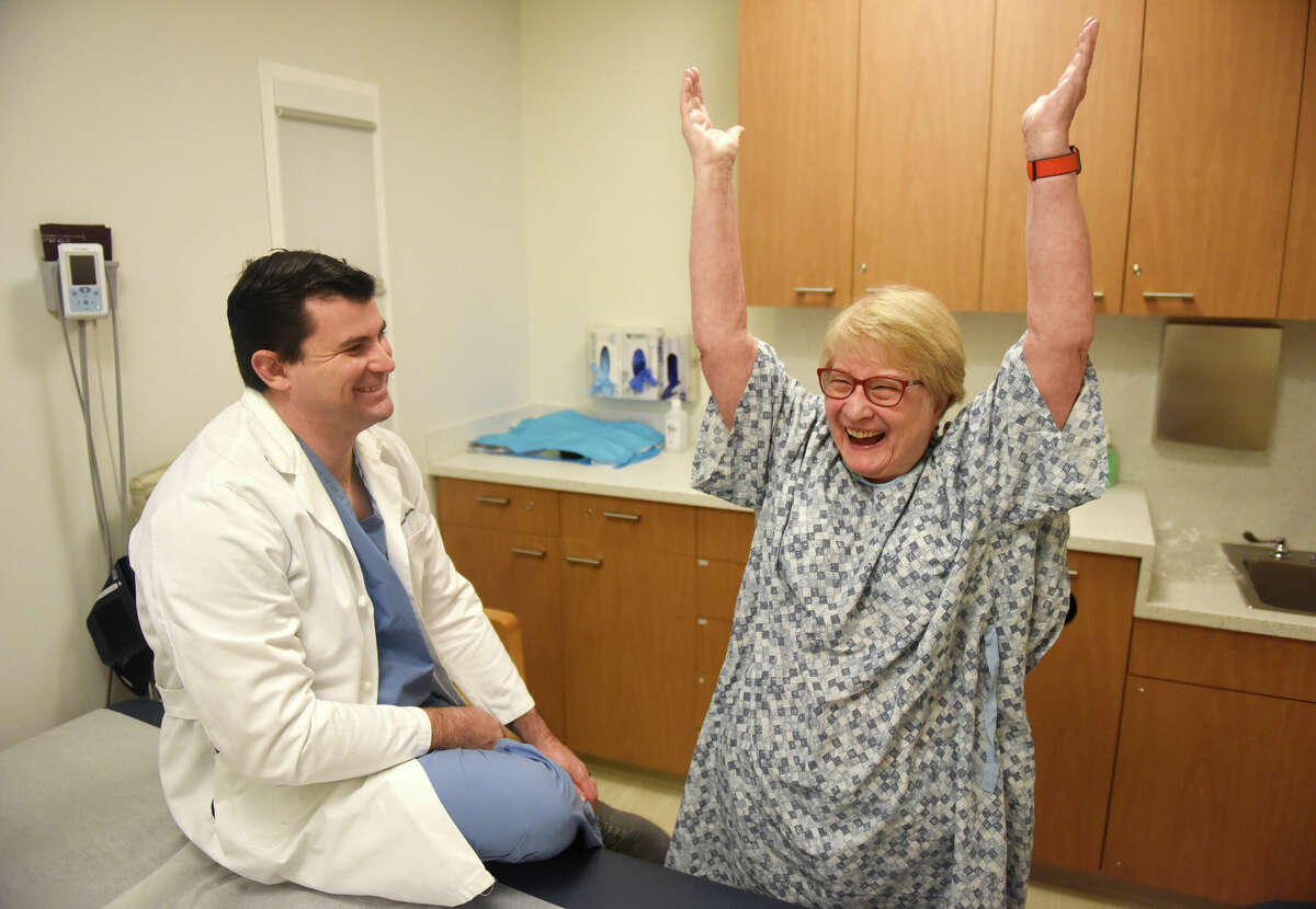 Former Greenwich High School science teacher Arleene Ferko shows her improved range of motion after surgery with Dr. Sam Taylor, one of her former students, at Hospital for Special Surgery Outpatient Center in Stamford, Conn. Monday, Jan. 23, 2023. Ferko reconnected with Dr. Taylor for the first time in almost 25 years to perform a reverse shoulder replacement surgery.