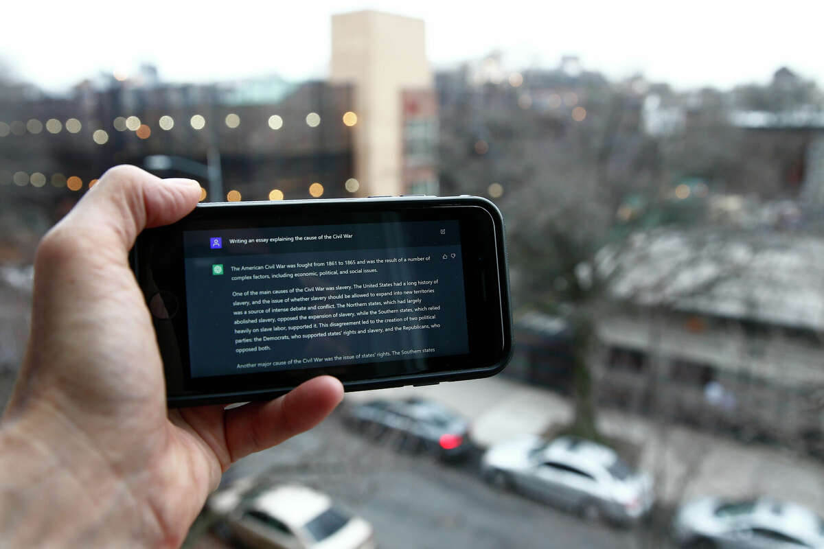 A ChatGPT prompt is displayed on a mobile device near a public school in Brooklyn, N.Y. The artificial intelligence writing tool doesn’t present college professors with problems they haven’t seen before.