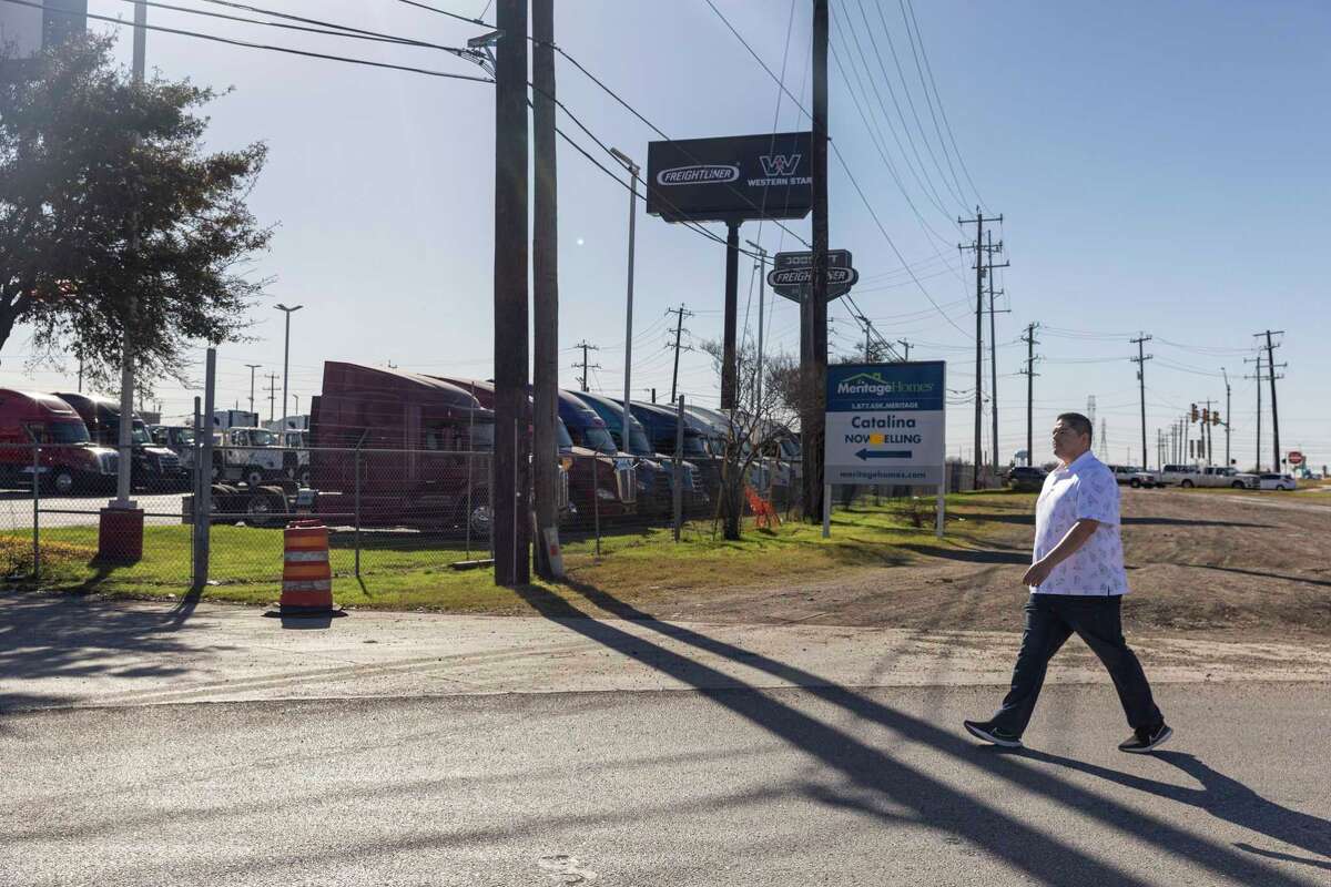 San Antonio truck driver Rolando Denova Jr., walks past the entrance to Doggett Freightliner in Converse. He seeks up to $2 million in damages from the business over the loss of his truck
