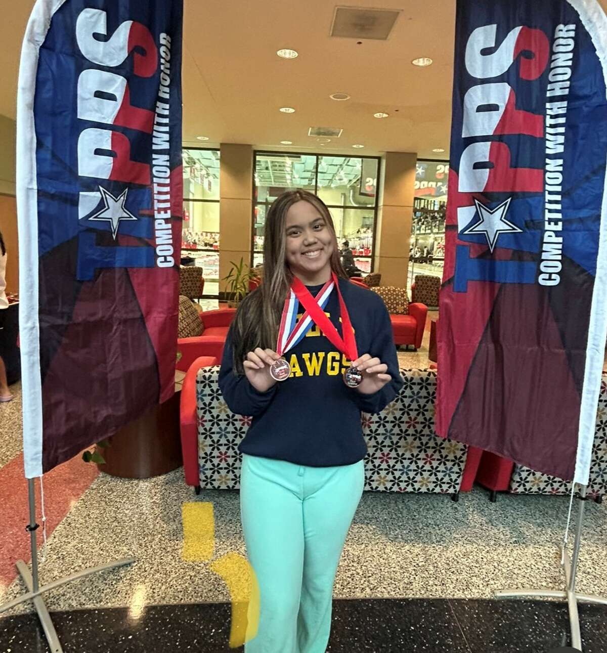 Kelsy Elgar poses with her medals at the University of Houston after qualifying for the state swim meet. 