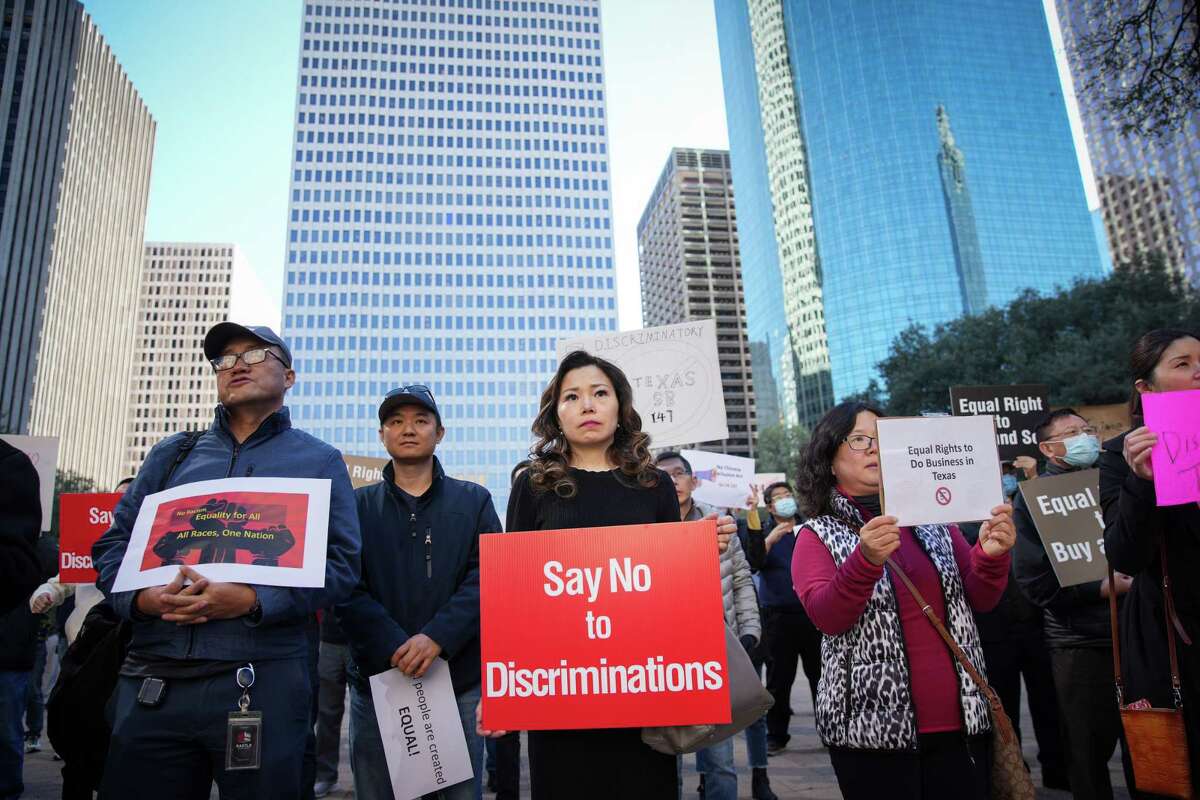 Protesters hold signs as politicians denounce SB 147 during a protest and press conference Monday, Jan. 23, 2023, at Houston City Hall in Houston.