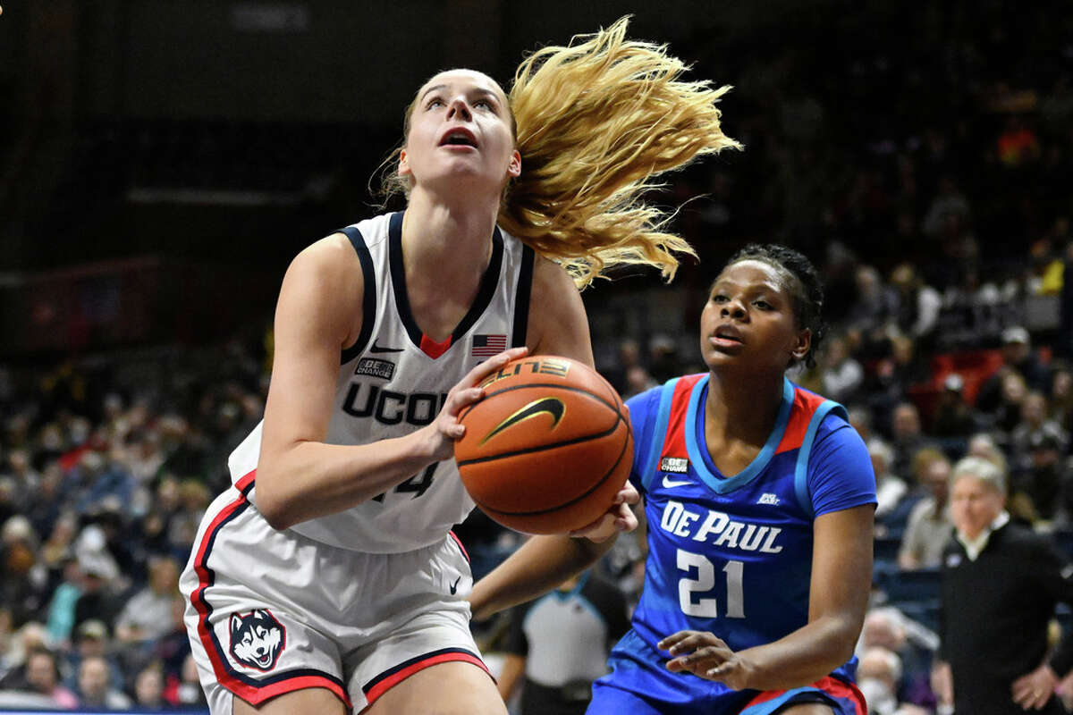 UConn's Dorka Juhasz (14) shoots as DePaul's Darrione Rogers (21) defends in the first half of an NCAA college basketball game, Monday, Jan. 23, 2023, in Storrs, Conn. (AP Photo/Jessica Hill)