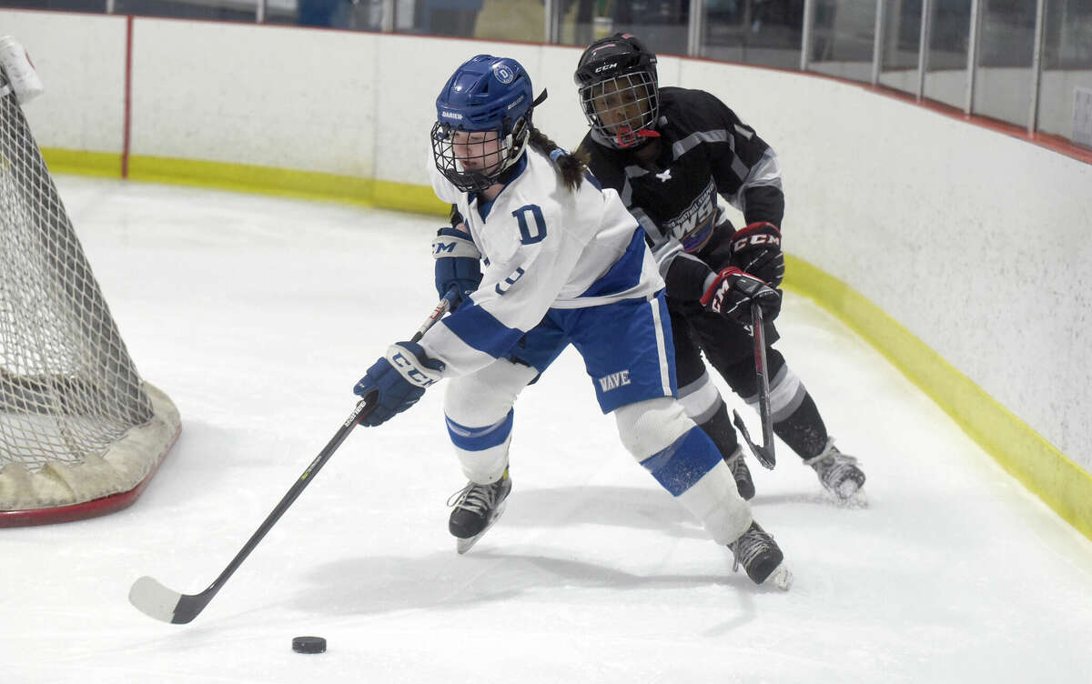 Darien's Natalie Beach (9) skates with the puck while Liz Brown of the Stamford/Westhill/Staples co-op pursues during a girls ice hockey game at the Darien Ice House on Wednesday, Jan. 18, 2023.