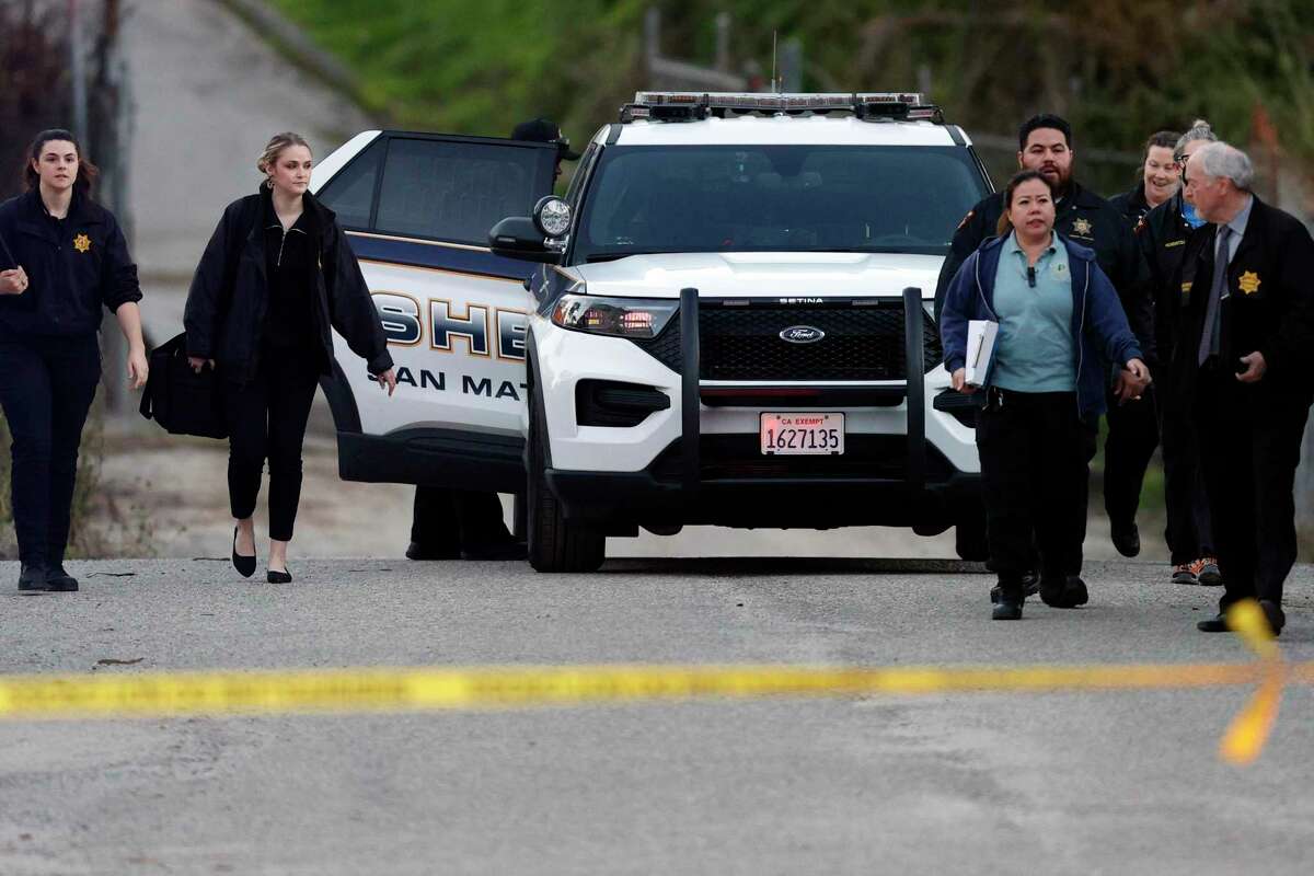 San Mateo County Sheriffs officers and EMS personnel gather along a road at a location near where four people were found shot to death on Monday, January 23, 2023, in half Moon Bay, Calif.