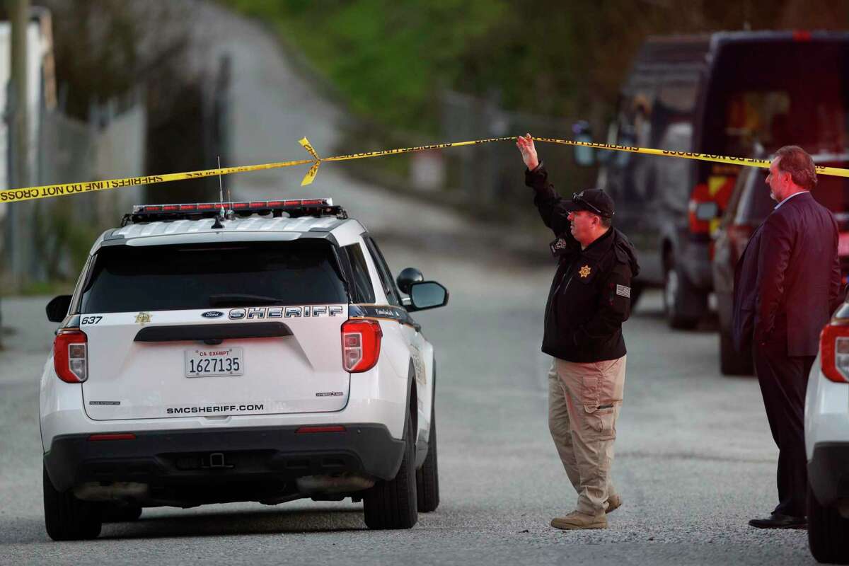 A San Mateo County Sheriffs officer hold crime scene tape for a vehicle to pass by at a location near where four people were found shot to death on Monday, January 23, 2023, in half Moon Bay, California