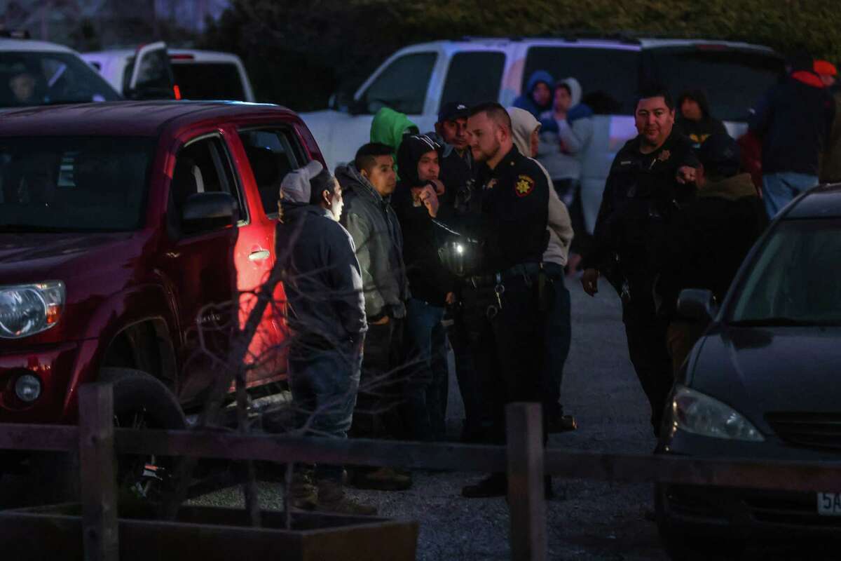A sheriff talks with a man who appeared to be a worker at the scene of a deadly shooting where several fatalities occurred off of Highway 92 in Half Moon Bay, Calif., on Monday, Jan. 23, 2023.