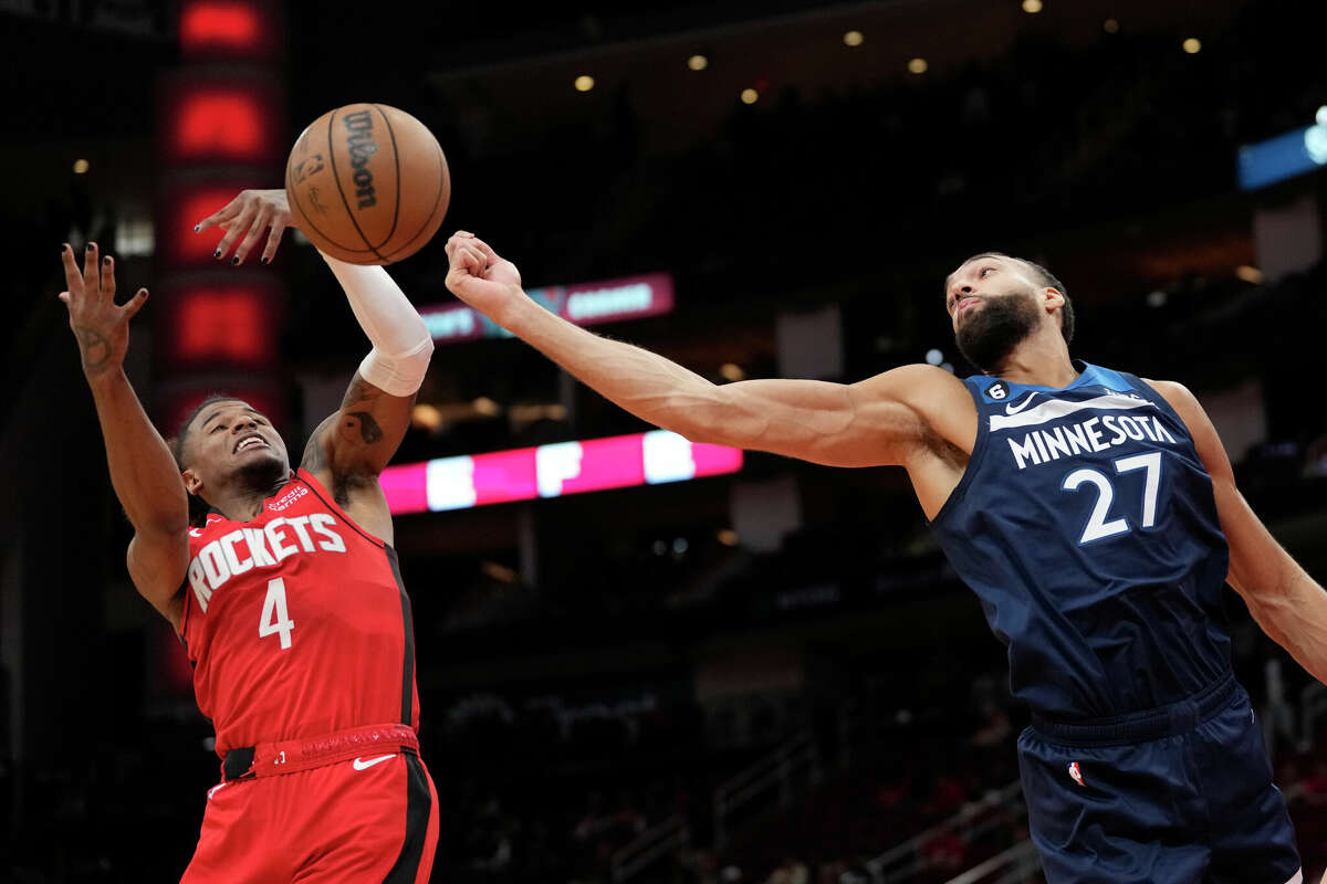 Houston Rockets' Jalen Green (4) and Minnesota Timberwolves' Rudy Gobert (27) reach for a rebound during the first half of an NBA basketball game Monday, Jan. 23, 2023, in Houston. (AP Photo/David J. Phillip)