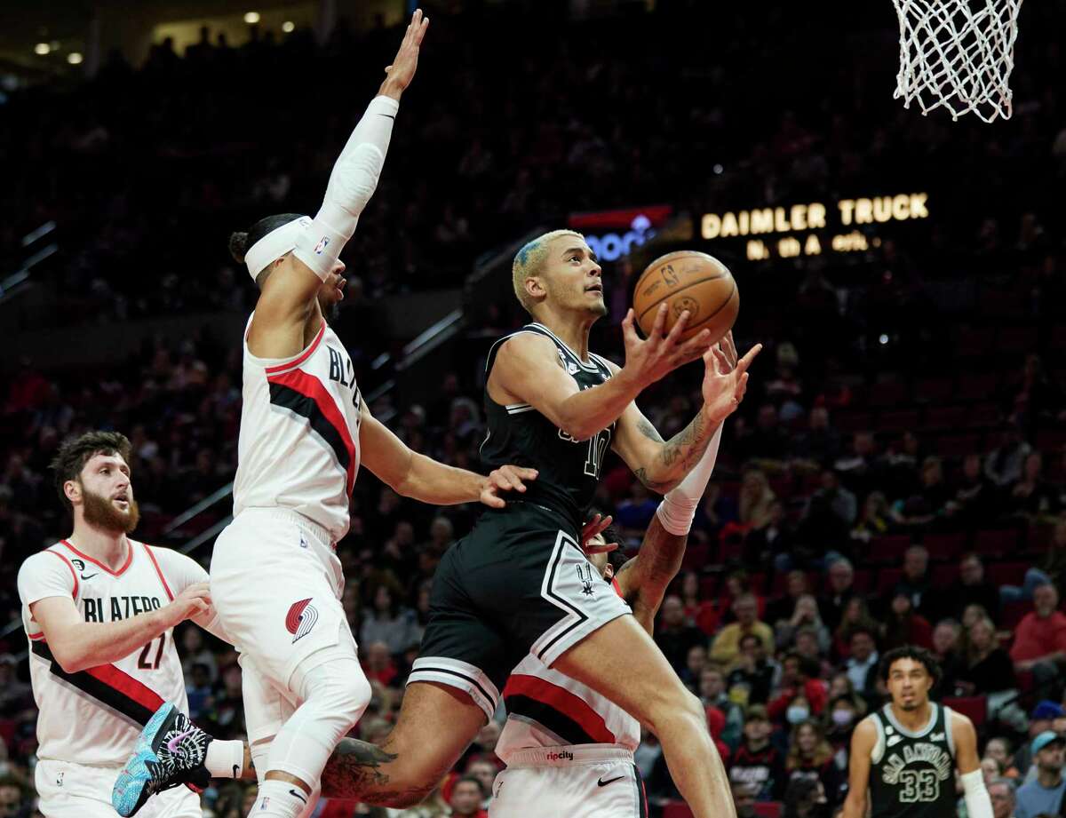 San Antonio Spurs forward Jeremy Sochan, right, shoots in front of Portland Trail Blazers guard Josh Hart, center, and center Jusuf Nurkic, left, during the first half of an NBA basketball game in Portland, Ore., Monday, Jan. 23, 2023. (AP Photo/Craig Mitchelldyer)