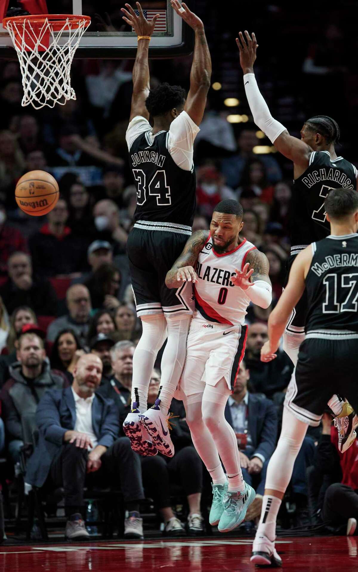 Portland Trail Blazers guard Damian Lillard (0) passes the ball away from San Antonio Spurs forward Stanley Johnson, left, and guard Josh Richardson, top right, during the first half of an NBA basketball game in Portland, Ore., Monday, Jan. 23, 2023. (AP Photo/Craig Mitchelldyer)