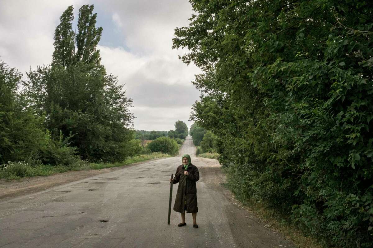 An elderly Ukrainian villager walks on the outskirts of Dibrova in July. The low birth rate in that and other countries will pose more challenges this century than climate change.