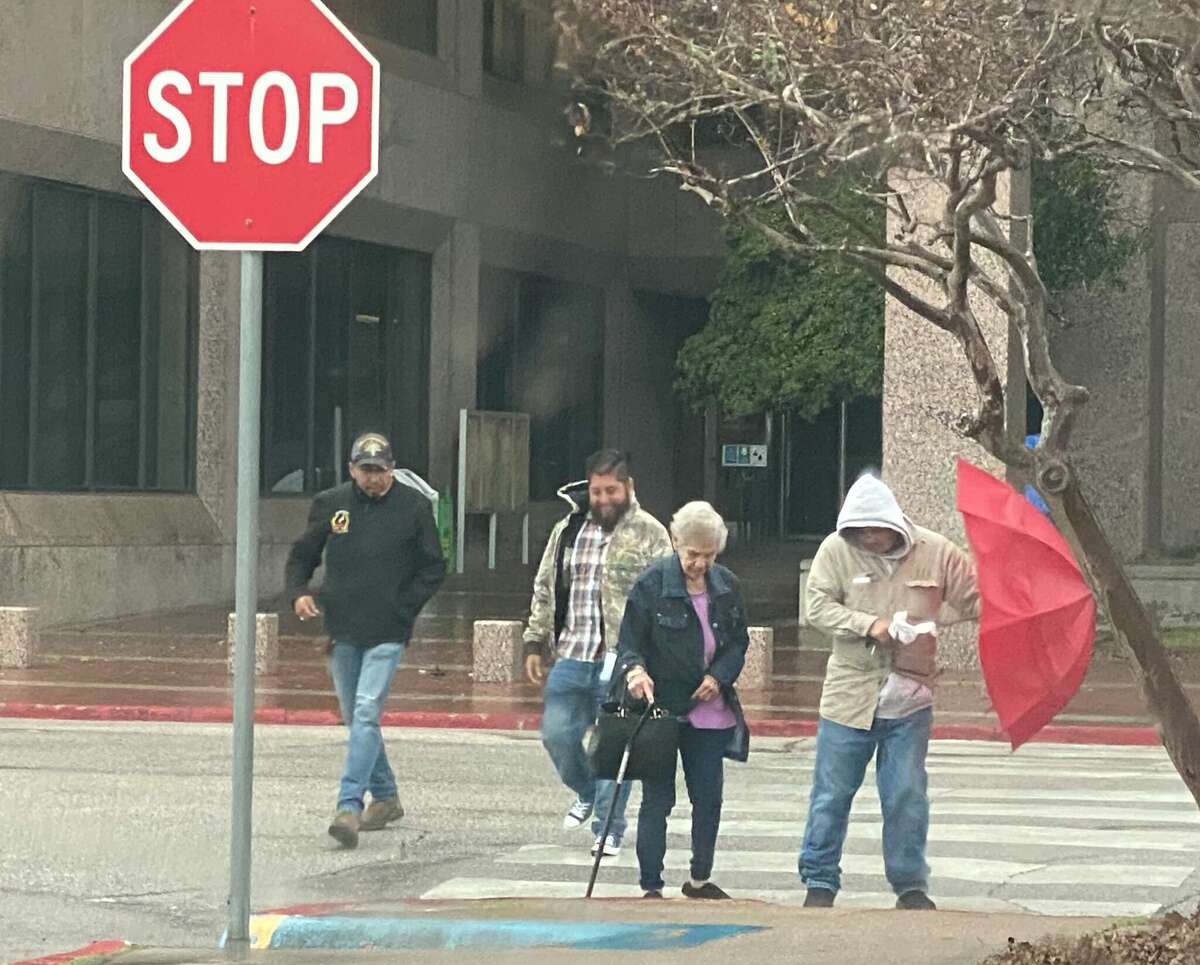 People struggle to walk and keep hold of umbrellas as they exit the Jefferson County Courthouse Tuesday afternoon. Photo taken Jan. 24, 2023. Photo by Kim Brent/The Enterprise