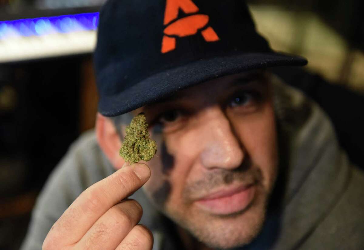 Joshua "Mirk" Mirsky holds a marijuana bud at his recording studio on Tuesday, Jan. 24, 2023, at the Washington Ave. Armory in Albany, N.Y. Mirsky will soon be one of the first four recreational marijuana dispensary owners in the Capital Region.