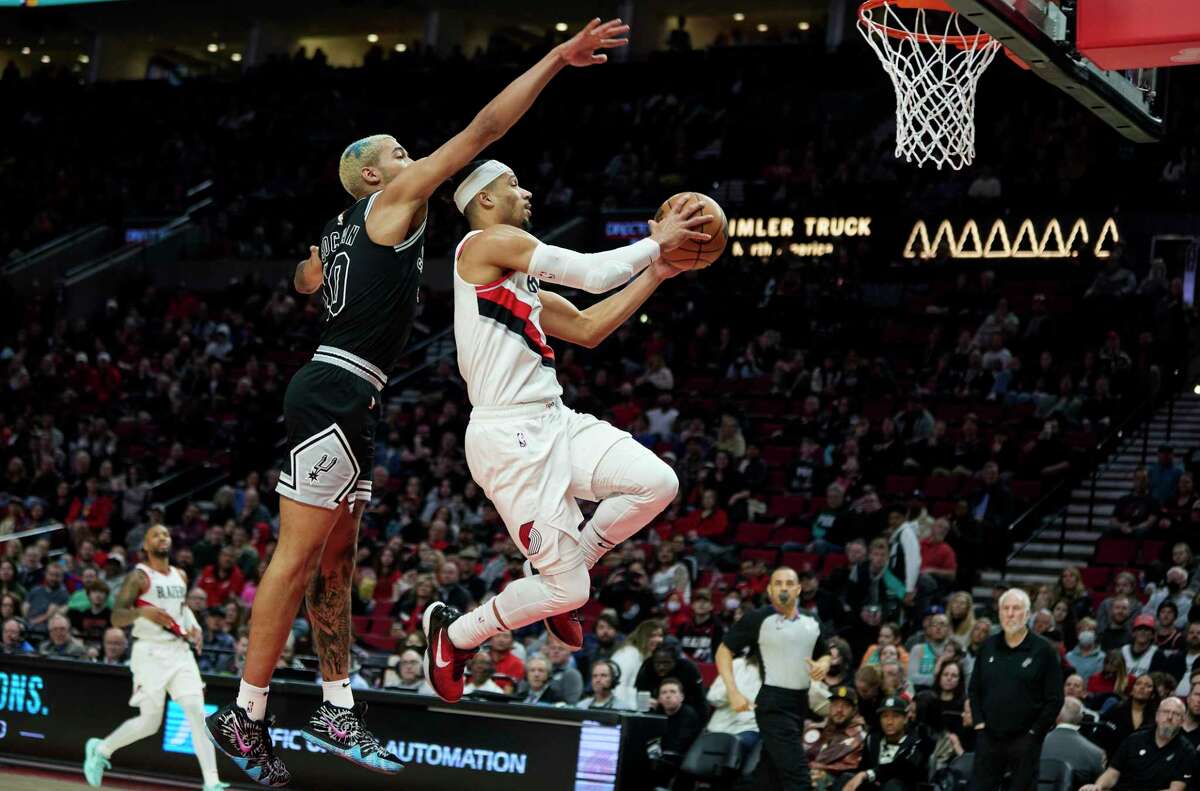 Portland Trail Blazers guard Josh Hart, right, goes up to shoot in front of San Antonio Spurs forward Jeremy Sochan during the second half of an NBA basketball game in Portland, Ore., Monday, Jan. 23, 2023. (AP Photo/Craig Mitchelldyer)