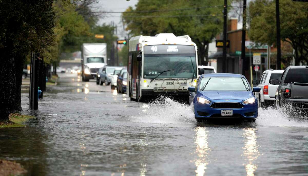 Cars navigate Yale Street which was flooded between 19th and 20th Streets during a heavy downpour from thunderstorms that came across the area on Tuesday, Jan. 24, 2023 in Houston.