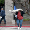 A woman uses a sweater after her umbrella failed in gusting winds while leaving the Jefferson County Courthouse, which closed as heavy storms with high winds moved through the region Tuesday afternoon. Photo made Tuesday, January 24, 2023 Kim Brent/Beaumont Enterprise