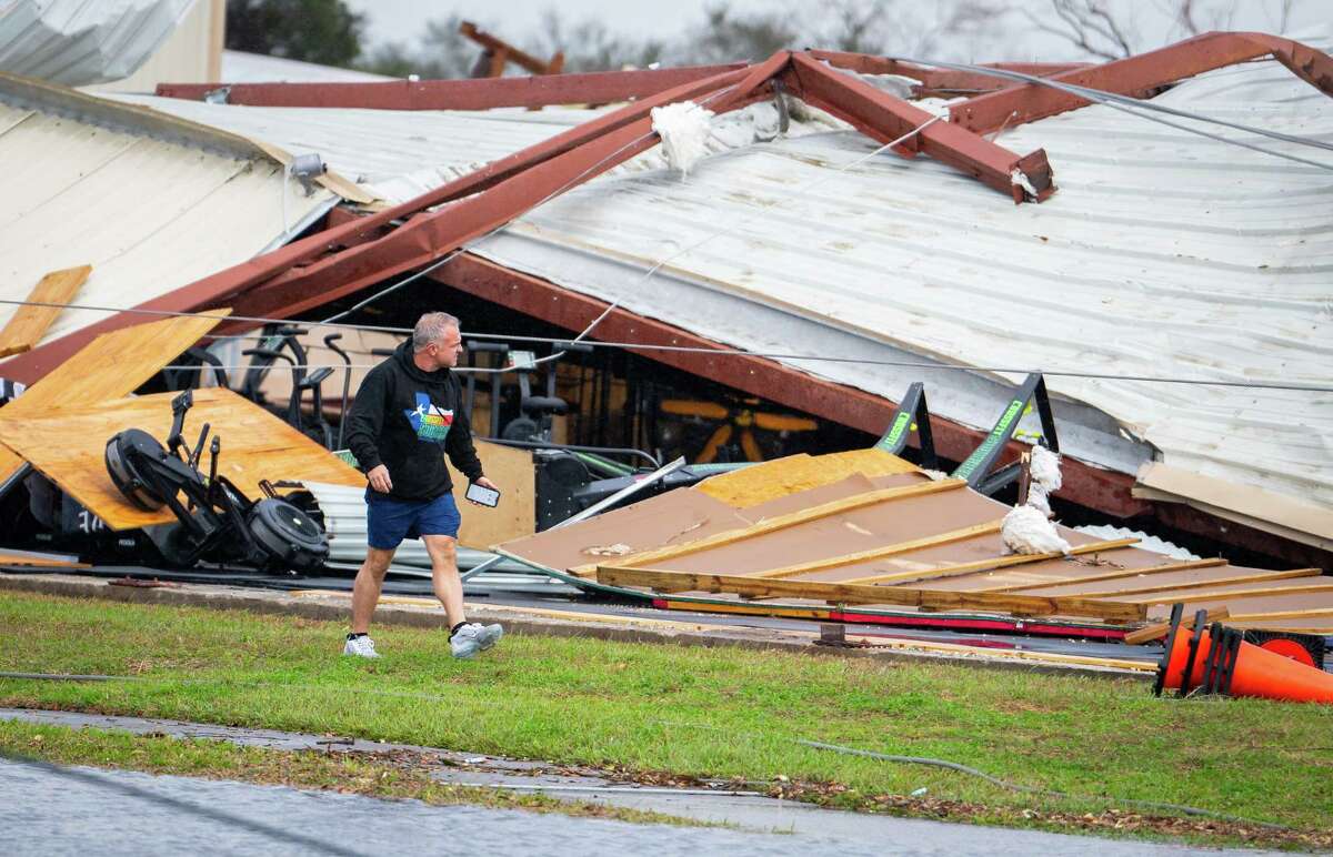 A man walks by a former CrossFit gym that collapsed where a tornado was reported to pass along Mickey Gilley Boulevard near Fairmont Parkway, Tuesday, Jan. 24, 2023, in Pasadena.