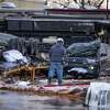 A man walks through a parking lot containing multiple overturned vehicles, including a trailer that was in a parking lot across the street, according to people at the scene, where a tornado was reported to pass along Mickey Gilley Boulevard near Fairmont Parkway, Tuesday, Jan. 24, 2023, in Pasadena.