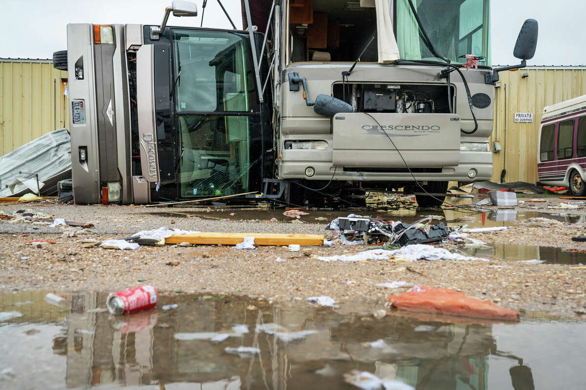 An overturned RV smashes against another RV in a parking lot by a Moose Lodge where a tornado was reported to pass along Mickey Gilley Boulevard near Fairmont Parkway, Tuesday, Jan. 24, 2023, in Pasadena, Texas. (Mark Mulligan/Houston Chronicle via AP)