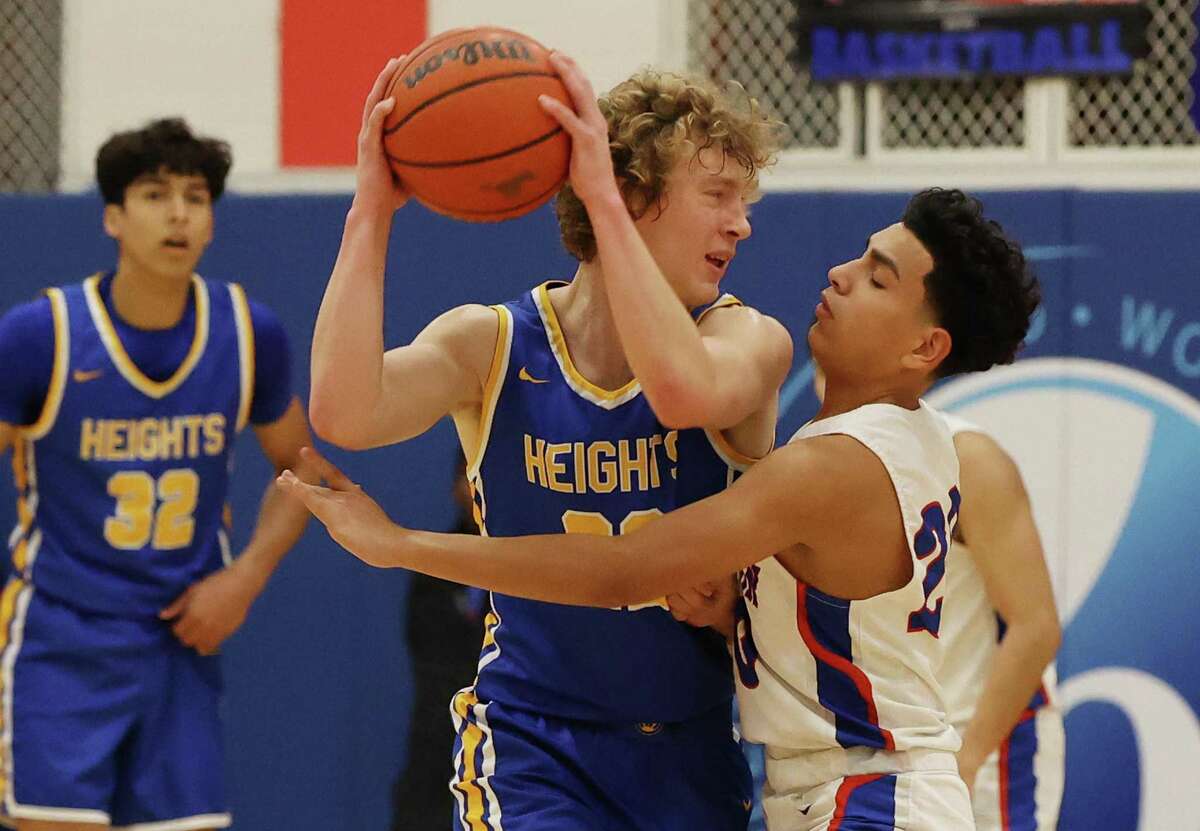 Alamo Heights’ Flin Cooper keeps the ball away from Jefferson’s Adrian Reyna during Tuesday night’s 58-33 win at Jefferson.