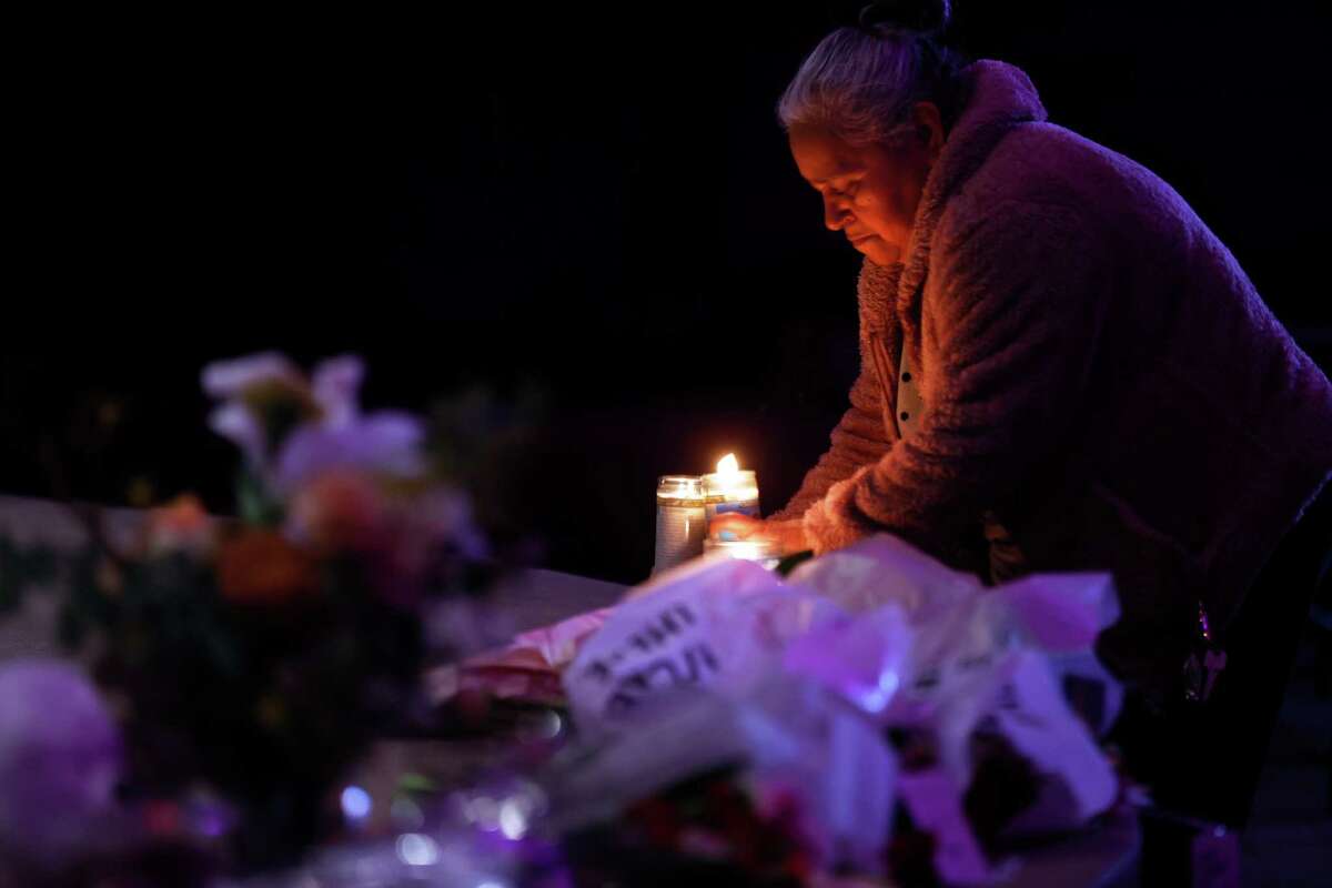Merced Martinez places a candle at a memorial for victims of the mass shooting in Half Moon Bay, Calif., on Tuesday, January 24, 2023. Several memorials have been left in town and also at the sites where 7 were killed.