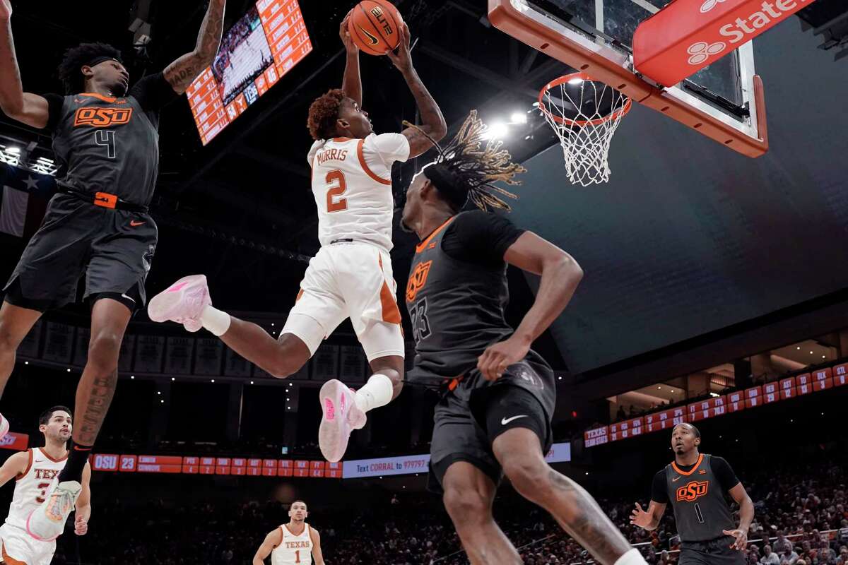Texas guard Arterio Morris (2) drives to the basket past Oklahoma State guard Woody Newton (4) and forward Tyreek Smith (23) during the second half of an NCAA college basketball game in Austin, Texas, Tuesday, Jan. 24, 2023. (AP Photo/Eric Gay)
