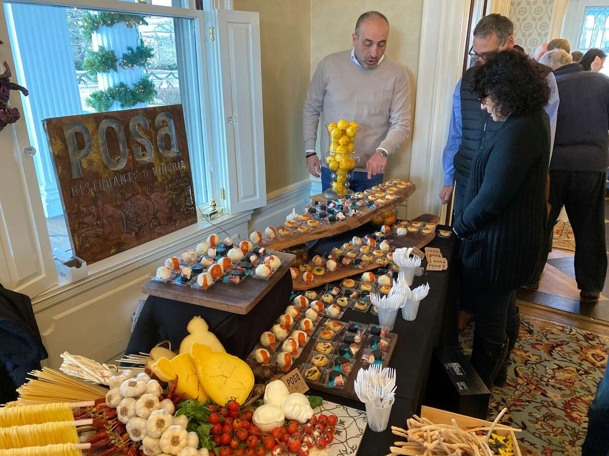 Nearly 30 Ridgefield restaurants and wine shops will showcase their wares and connect with customers at the 2023 Taste of Ridgefield on Feb. 5. Above, staff from Posa Ristorante & Vineria connect with clients over food.