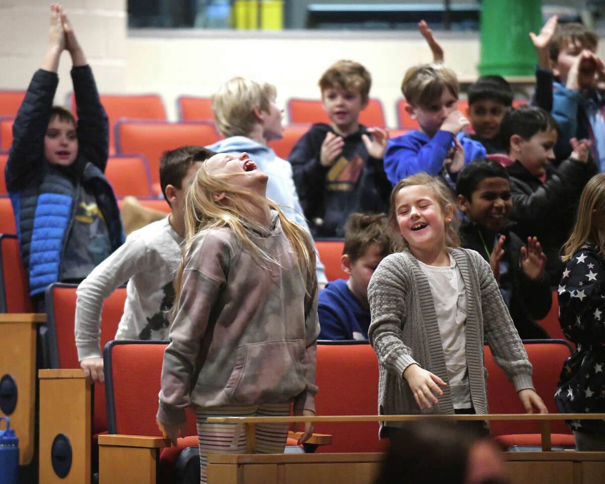 Third graders Annabelle Lewis, left, and Millie Allen cheer as the Dalí­ Quartet performs an educational concert for elementary strings students at Darien High School in Darien, Conn. Wednesday, Jan. 25, 2023. The acclaimed quartet performed a skillful repertoire of Latin American classical pieces during an interactive and energetic show to a packed house of new strings players in grades three through five.