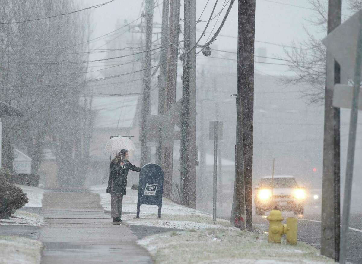 A lone pedestrian in the snow posts a letter in a mail box along Main Street on Wednesday afternoon. January 25, 2023, Danbury, Conn.
