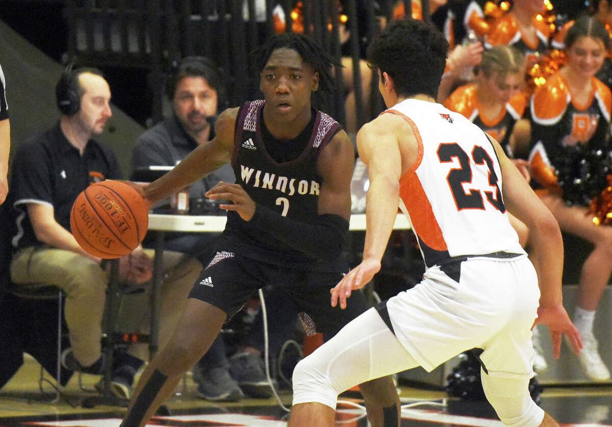 Windsor's Quintin Floyd (2) is on offense, while Ridgefield's Ben Klotz (23) is on defense in the CIAC division.  I Boys Basketball Quarterfinals at Ridgefield on Monday March 14, 2022.