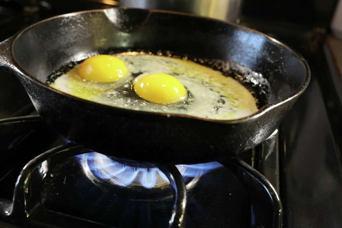 CHICAGO, ILLINOIS - JANUARY 12: In this photo illustration, eggs cook in a cast iron pan over flames on a natural gas-burning stove on January 12, 2023 in Chicago, Illinois. Consumers and politicians have voiced concern after the commissioner of the Consumer Product Safety Commission (CPSC) recently suggested that gas stoves were a health hazard, leading people to believe that they would be banned. (Photo Illustration by Scott Olson/Getty Images)