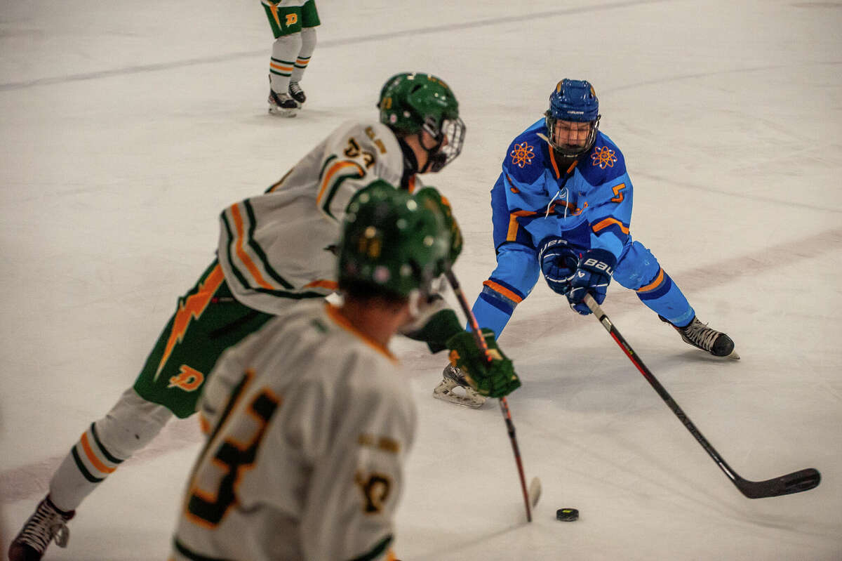 Midland's Ben Haney reaches for a puck in a rivalry game on Jan.  25, 2023 at the Midland Civic Arena.