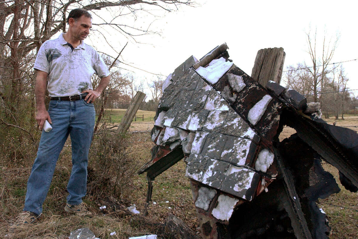 STS-107 (2/2/03) McPowell stands next to what is believed to be the suspected damaged left wing of the downed space shuttle Columbia, on his property in Nacogdoches County, Sunday night.  He found the wreck Sunday morning complete with several damaged refractory tiles (NO ONE WANTS TO KNOW THE EXACT LOCATION!!!!) (Karen Warren/Houston Chronicle) HOOKRON COMMENT (02/03/2003): McPowell looks at it for what he thinks is a fragment From the wing of a shuttle he found on his property in Nacogdoches County.  Houston Chronicle Special Report: Columbia's Last Mission.