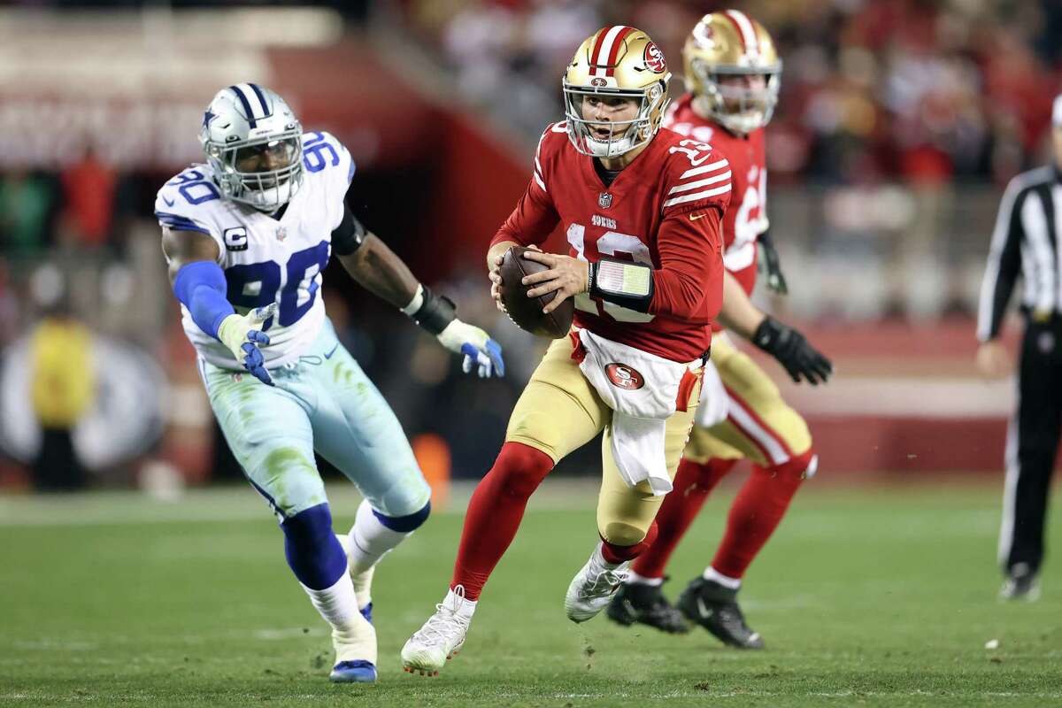49ers quarterback Brock Purdy tucks the ball and runs during a game against the Dallas Cowboys.