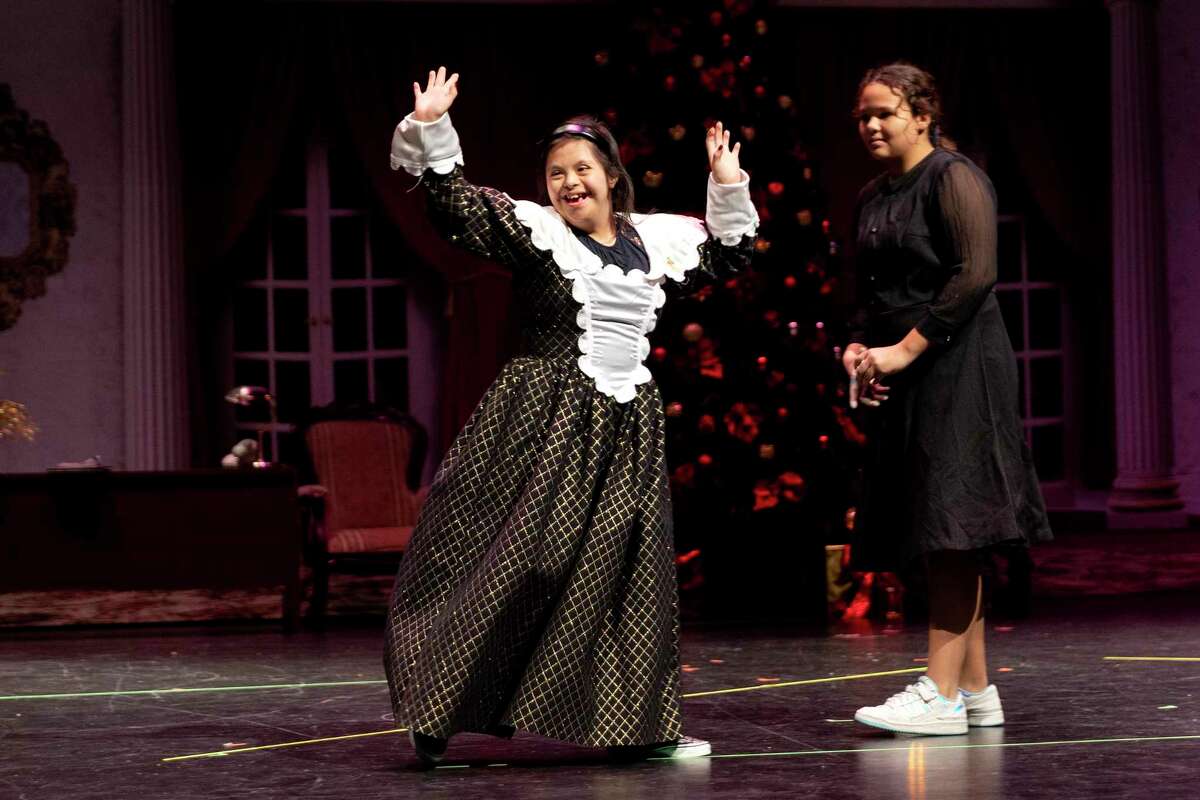 Arianna Vera, 13, turns around and waves during the curtain call ending the dress rehearsal of “Annie Jr.” while her student mentor, Makayla Day, waits for her to follow her off stage. Half of the musical’s cast are kids from Southwest ISD’s special education program, the other half are their student mentors.