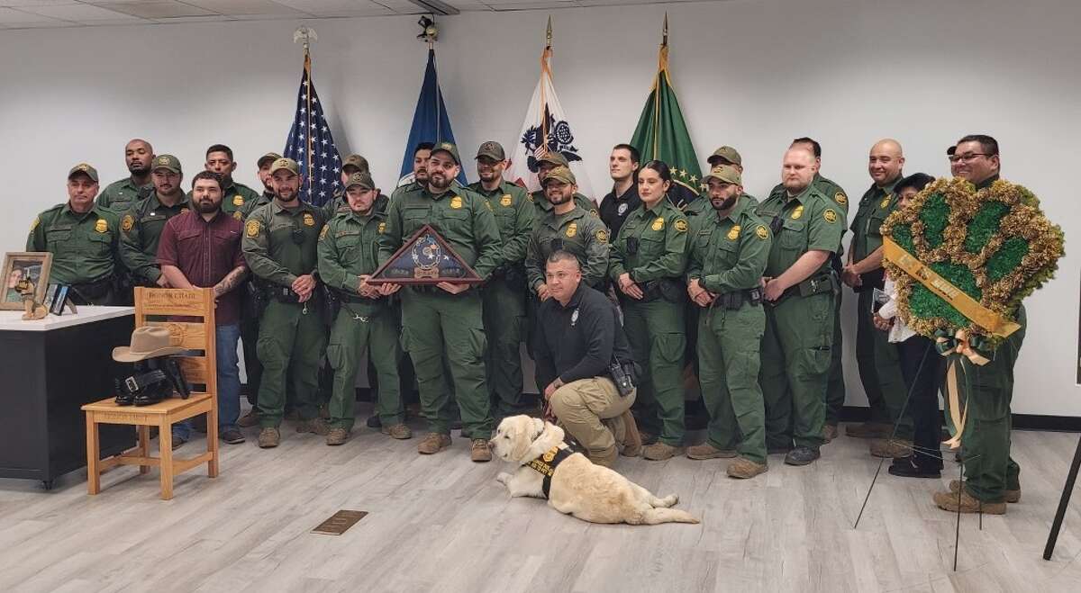 Support Canine Pearl poses for a photo with a group of Border Patrol agents.