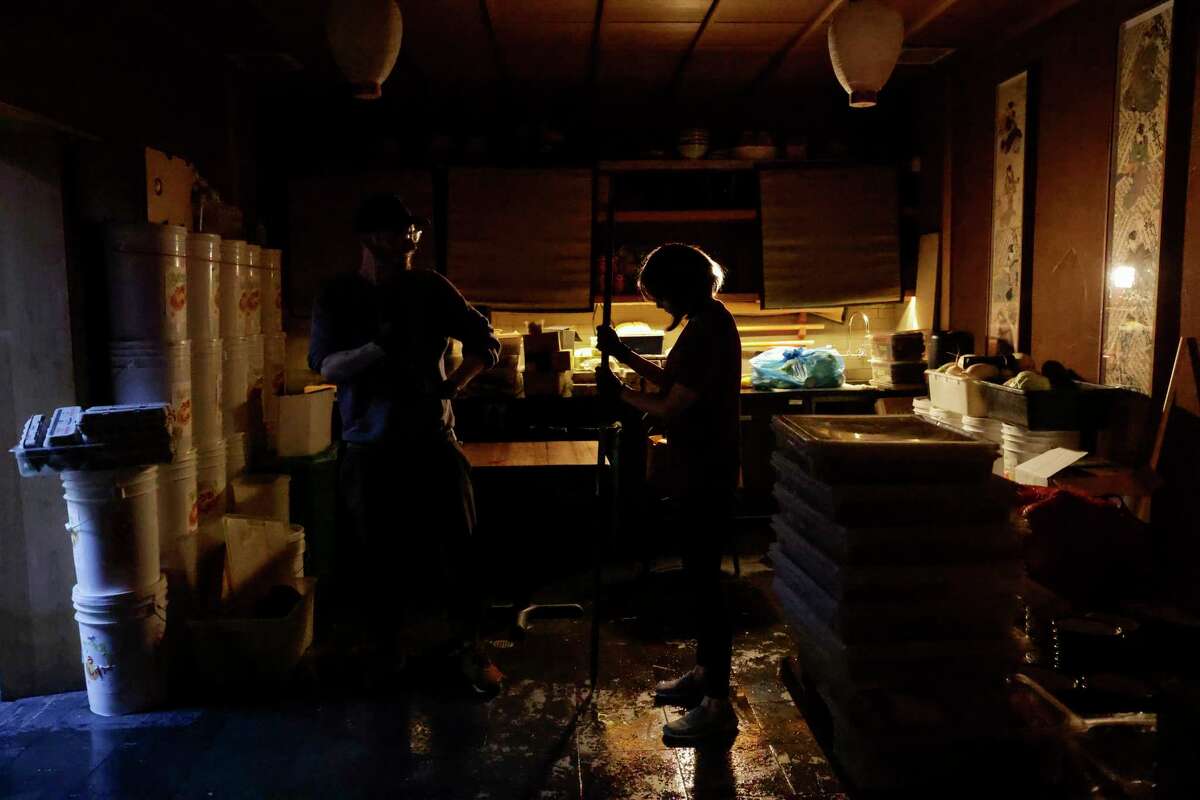 Aaron Linenberger and Akiko Mochizuki, employees at Rintaro restaurant in San Francisco, clean up from floodwaters that rose to several feet inside the restaurant. The city is launching a survey in an effort to tally all storm damage.