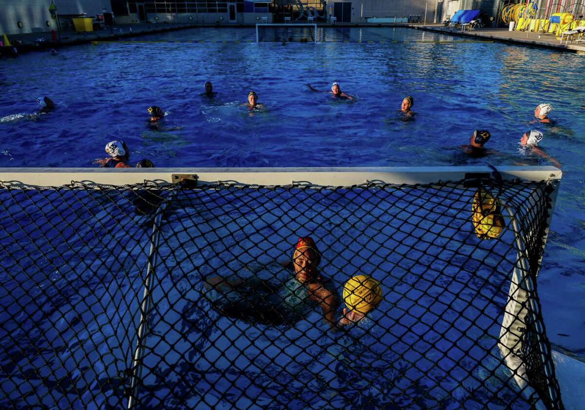 Isabel Williams, bottom, one of the few Black water polo stars in the nation, a future Olympian and the starting goalkeeper for Cal women's water polo, practices with her teammates at Legends Aquatic Center on Tuesday, January 24, 2023, in Berkeley, Calif.