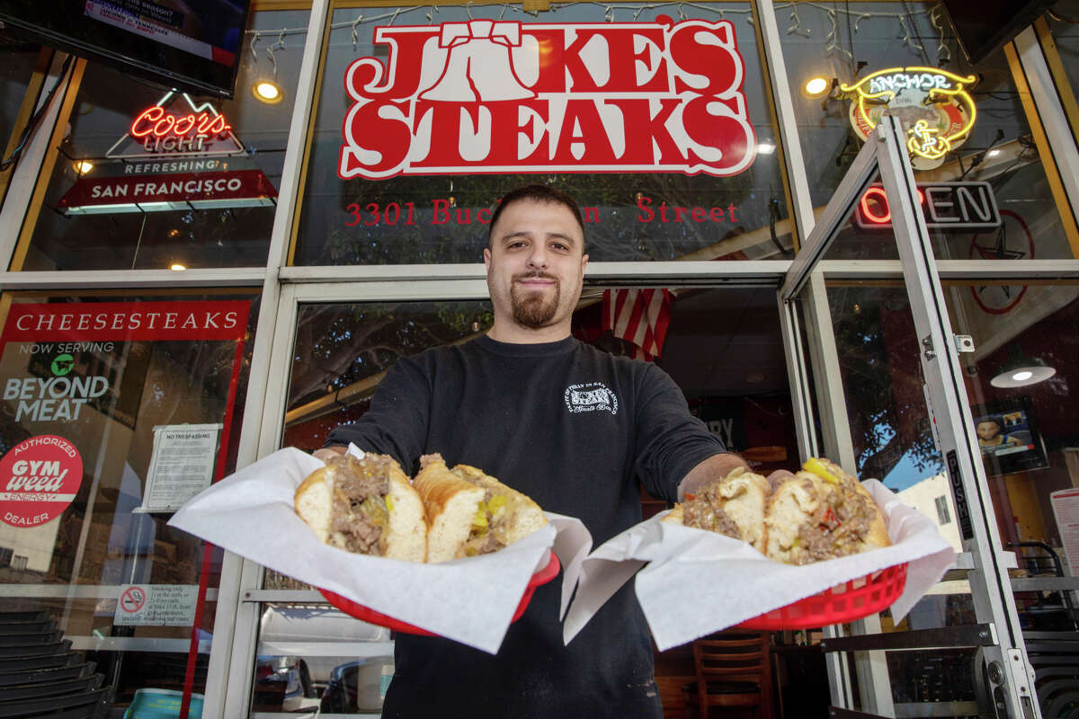 Owner Nasri Mufarreh holds two Philly cheesesteaks he just grilled up at Jake's Steaks in San Francisco on Thursday.