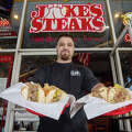 Owner Nasri Mufarreh holds two Philly cheesesteaks he just grilled up at Jake's Steaks in San Francisco, California on Jan. 26, 2023.