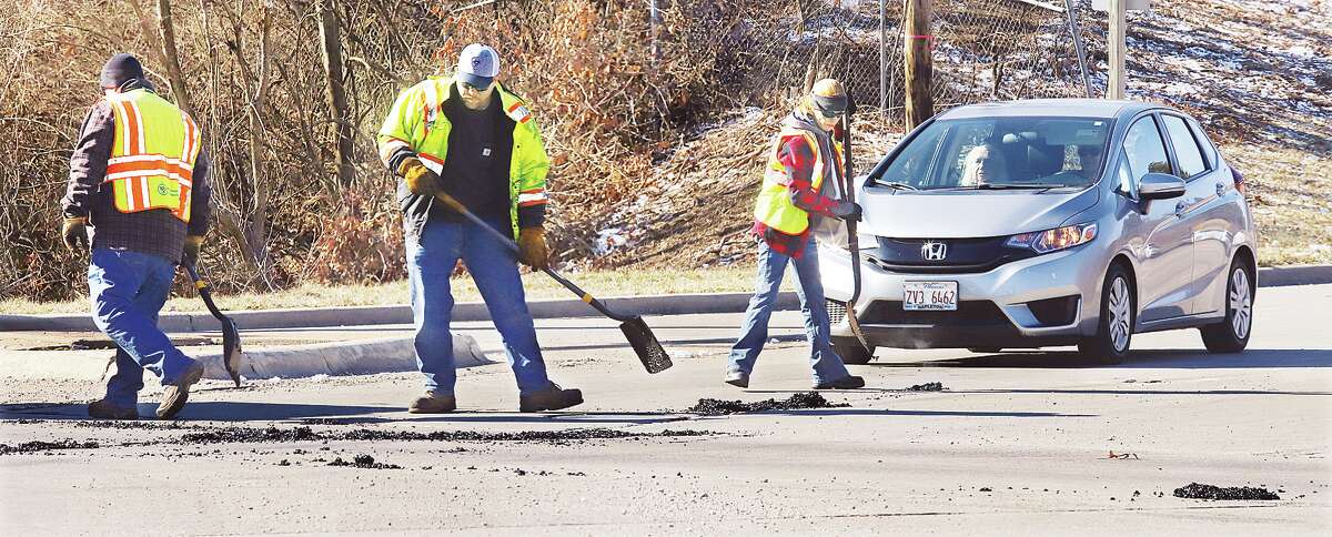 John Badman|The Telegraph Workers from the Illinois Department of Transportation were putting down hot asphalt Friday in the intersection MLK Bouelvard and 20th Street in Alton on Friday. The roller coaster weather of freezing and thawing has begun the annual ritual of dodging winter potholes as you drive. 