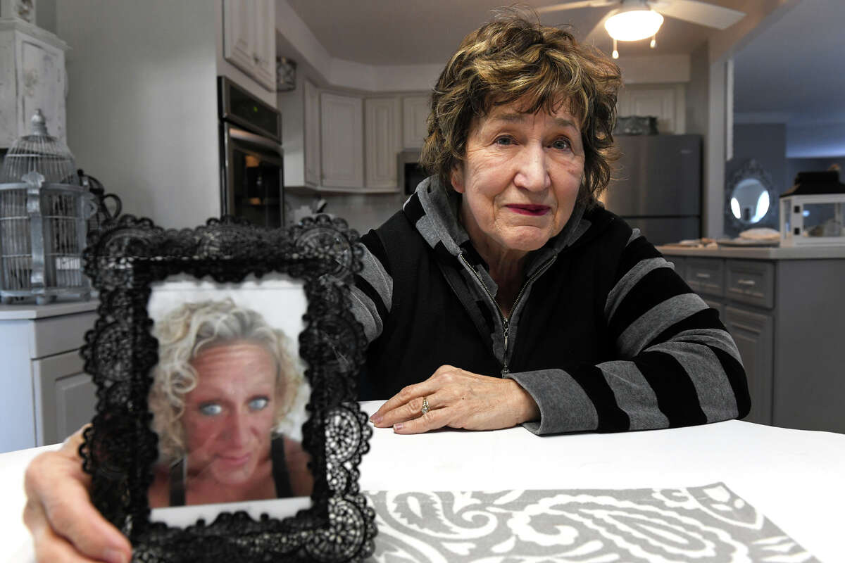 Valerie Booth, Jennifer Sullivan’s mother, poses with a photograph of her daughter during an interview in her home in Milford, Conn. Jan. 27, 2023. Sullivan has been missing for over a year.