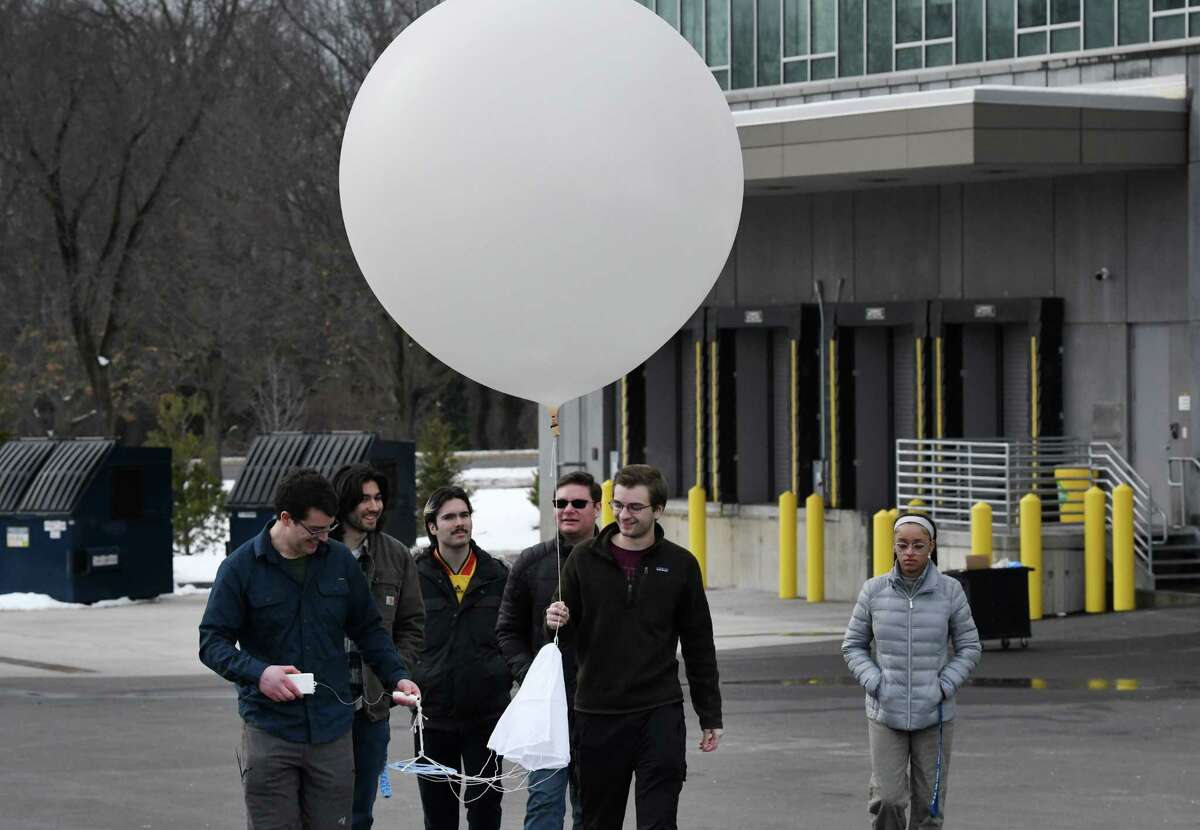Jason Covert, calibration manager at New York Mesonet, left, and Erik Creighton, student assistant at New York Mesonet, right, prepare to launch a National Weather Service weather balloon on Friday, Jan. 27, 2023, at the ETEC BUILDING on the University at Albany campus in Albany, N.Y. UAlbany students are taking on the National Weather Service at Albany’s role of launching weather balloons while NWS sorts out future plans. Launches will take place until end of March.